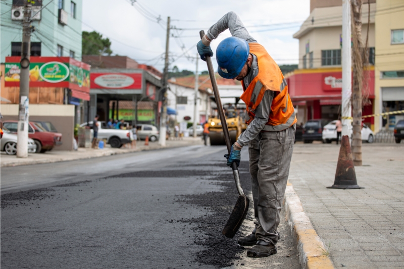 an image of a construction worker applying asphalt on road