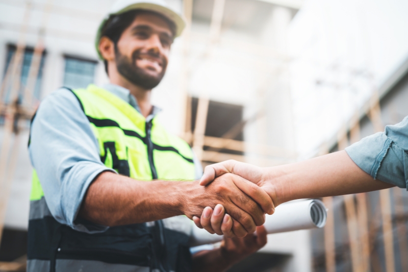 An image of a happy construction worker shaking hands